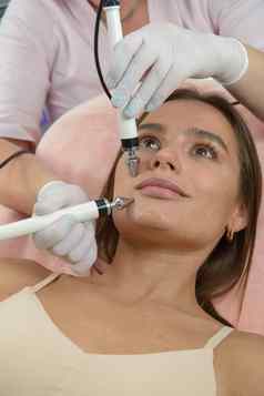 美丽的女人水疗中心诊所接收刺激电面部治疗治疗师特写镜头女脸在临床上治疗
