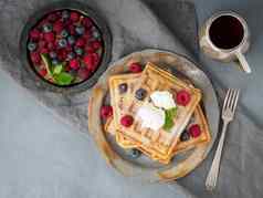比利时华夫饼树莓巧克力糖浆早餐茶黑暗背景前视图