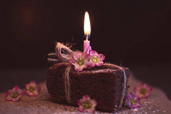 ฺ布朗尼candlechocolate巧克力蛋糕蛋糕坚果单生日蜡烛火焰吹流动烟集黑暗背景紫色的花复制空间