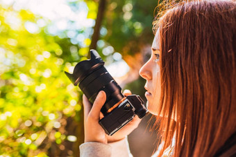 年轻的女人业余摄影师采取图片山景观年轻的红色头发的人拍摄野生动物旅行
