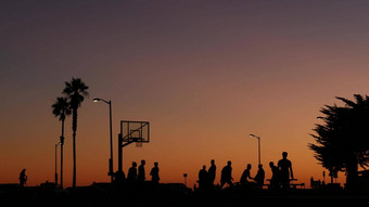 人篮球法院玩篮子球游戏日落海滩加州
