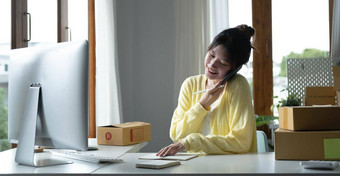 肖像亚洲女人电子商务员工坐着办公室完整的包表格移动PC智能手机锻造业务电子商务技术交付业务