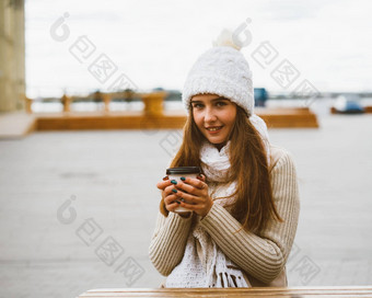 美丽的年轻的女孩相机持有咖啡茶可重用的塑料杯子秋天冬天女人温暖的衣服坐着海滨波罗的海海港口温暖热喝