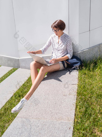 女人坐在移动PC城市公园板凳上自由职业者工作学生学习远程在<strong>户外</strong>现代生活方式<strong>夏天</strong>共鸣<strong>户外</strong>工作场所