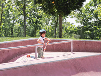 男孩游乐设施踢踏板车滑冰公园特殊的混凝土碗结构城市公园培训滑冰夏天