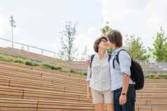 成人学生站户外观众木座位大学校园年轻的夫妇浪漫的日期夏天共鸣教育欧洲