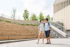 成人学生走户外观众木座位大学校园年轻的夫妇浪漫的日期夏天共鸣教育欧洲