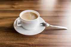 杯热咖啡飞碟勺子站木背景表格咖啡馆