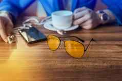 太阳镜移动电话智能手机杯子咖啡表格咖啡馆手商人