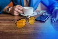 太阳镜移动电话智能手机杯子咖啡表格咖啡馆手商人