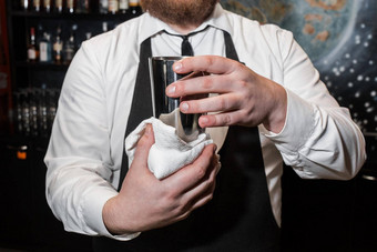 专业酒保持有金属瓶工具混合使含酒精的鸡尾酒湿巾白色布