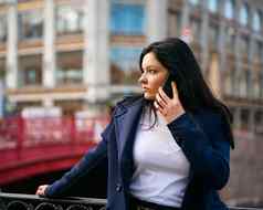 女人长头发会说话的电话秋天冬天女孩户外美丽的聪明的浅黑肤色的女人街圣彼得堡城市中心桥复制空间