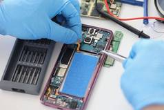 技术员修复破碎的移动电话集电池封面返回手机生活
