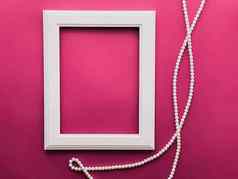 白色垂直艺术框架珍珠珠宝粉红色的背景平铺设计艺术作品打印照片专辑