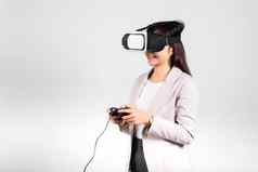 微笑女人信心兴奋穿耳机设备玩游戏虚拟现实经验操纵杆孤立的