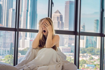 女人醒来早....公寓市中心区域视图摩天大楼生活噪音大城市概念睡眠