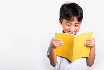 亚洲蹒跚学步的微笑快乐穿学生泰国统一的红色的裤子站持有阅读书