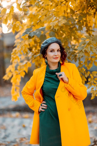 美丽的女人走在户外秋天穿黄色的外套绿色衣服年轻的女人享受秋天天气秋天内容