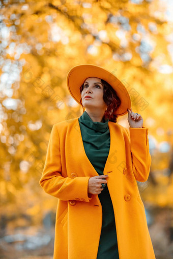 美丽的女人走在户外秋天穿黄色的外套黄色的他绿色衣服年轻的女人享受秋天天气秋天内容