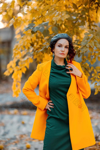 美丽的女人走在户外秋天穿黄色的外套绿色衣服年轻的女人享受秋天天气秋天内容