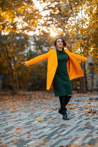 美丽的女人走在户外<strong>秋天</strong>穿黄色的外套绿色衣服年轻的女人享受<strong>秋天</strong>天气<strong>秋天内容</strong>