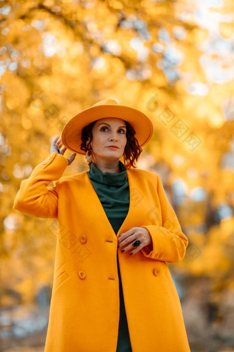 美丽的女人走在户外<strong>秋天</strong>穿黄色的外套黄色的他绿色衣服年轻的女人享受<strong>秋天</strong>天气<strong>秋天内容</strong>