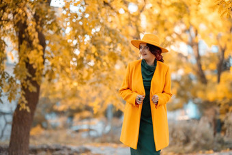 美丽的女人走在户外秋天穿黄色的外套黄色的他绿色衣服年轻的女人享受秋天天气秋天内容