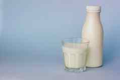 玻璃瓶白色牛奶突出显示蓝色的背景特写镜头