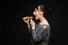 年轻的高加索人女人尾巴吃一块披萨