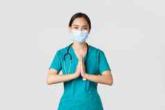 科维德冠状病毒疾病医疗保健工人概念充满希望的微笑亚洲女医生医生医疗面具实习医生风云持有手祈祷手势感谢白色背景