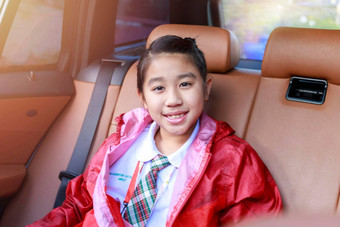 亚洲快乐学生微笑相机享受路旅行车女儿微笑相机内部车早....亚洲瘦坐着车学校家庭车
