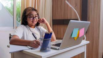 亚洲女孩耳机坐桌子上研究在线移动PC孩子穿耳机笔迹笔记本<strong>学习</strong>互联网教训检疫女孩<strong>学生学习</strong>虚拟互联网在线类学校由于科维德流感大流行