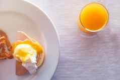 前视图关闭橙色汁玻璃蛋本尼迪克特早餐白色桌布食物喝概念前视图早餐挖走鸡蛋皇家