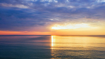 美丽的日落蛤海云天空背景日落热带海滩自然夏天概念峰日落海黄色的光反映云