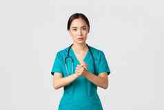 科维德医疗保健工人流感大流行概念充满希望的严肃的表情亚洲护士医生有关脸握紧手支持冠状病毒白色背景