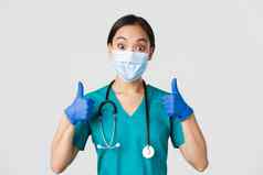 科维德冠状病毒疾病医疗保健工人概念逗乐微笑亚洲医生医生医疗面具橡胶手套显示竖起大拇指批准赞美不错的工作