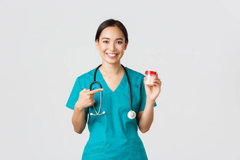 医疗保健工人防止病毒检疫运动概念微笑漂亮的亚洲女医生护士实习医生风云显示维生素指出药片推荐药物治疗白色背景