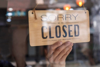 手亚洲老板零售咖啡商店女人把标志董事会关闭保护流感大流行冠状病毒关闭商店餐厅酒吧由于封锁检疫科维德
