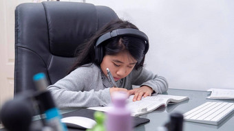 亚洲女孩研究在线笔记本<strong>电脑</strong>孩子穿耳机打字键盘笔记本<strong>学习</strong>互联网教训检疫<strong>学生学习</strong>互联网在线类学校新冠病毒