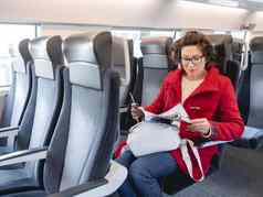 女人红色的露营装备外套读取杂志郊区火车信息印刷媒体旅行土地车辆