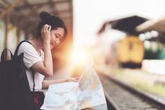 年轻的旅行者女人地图规划旅行火车站夏天旅行生活方式概念