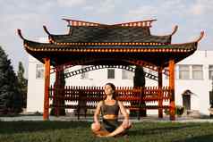 亚洲适合女孩坐着莲花位置冥想冥想放松在户外