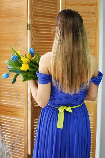 年轻的美丽的乌克兰女孩<strong>蓝色</strong>的衣服持有黄色的<strong>蓝色</strong>的<strong>郁金香</strong>梦想和平国家