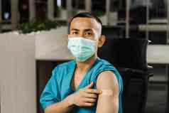 英俊的亚洲男人。接种疫苗冠状病毒显示补丁手臂科维德疫苗接种菲律宾男人。医疗面具