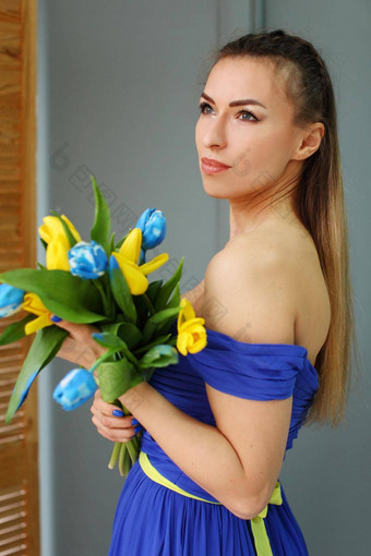 年轻的美丽的乌克兰女孩蓝色的衣服持有黄色的蓝色的郁金香梦想和平国家