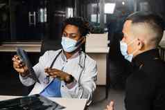 亚洲病人非洲医生任命骨折骨头脚黑色的外科医生显示x射线病人