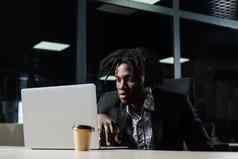 黑色的程序员工作移动PC共同办公空间英俊的非洲男人。移动PC办公室