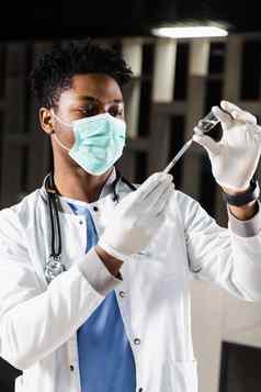 非洲医生医疗面具准备注入冠状病毒科维德疫苗黑色的医生白色医疗袍注射器使疫苗接种