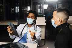 亚洲病人非洲医生任命骨折骨头脚黑色的外科医生显示x射线病人