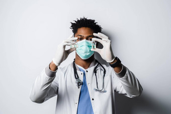 英俊的非洲医生冠状病毒科维德疫苗黑色的医生医疗面具持有疫苗白色背景